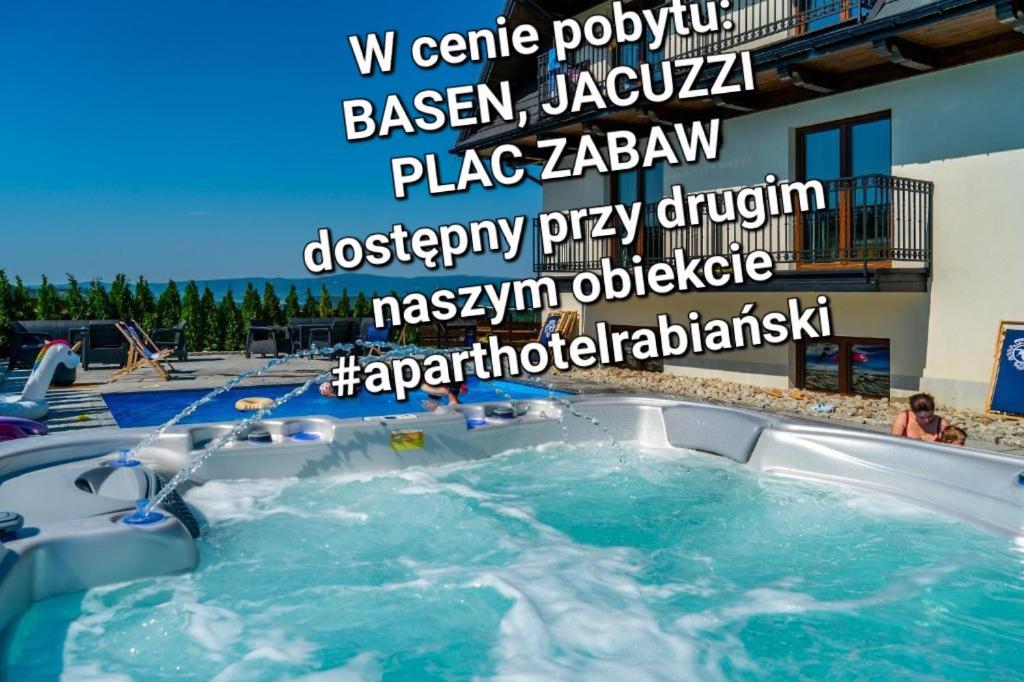 a hot tub in a swimming pool with water at Apartamenty Borysek De Lux in Białka Tatrzańska