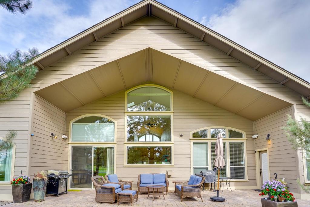 a house with blue chairs and a patio at Redmond Golf Getaway - Near Smith Rock State Park! in Redmond