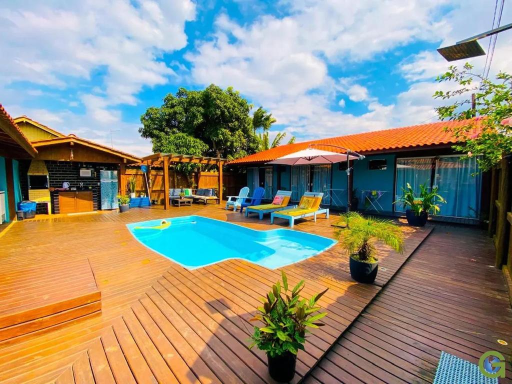 a patio with a swimming pool on a wooden deck at Pousada Inn Nature in Palhoça