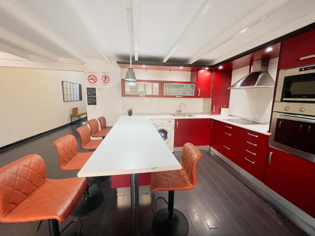 uma cozinha com uma mesa branca e cadeiras laranja em Carretas dúplex exterior derecha em Madri