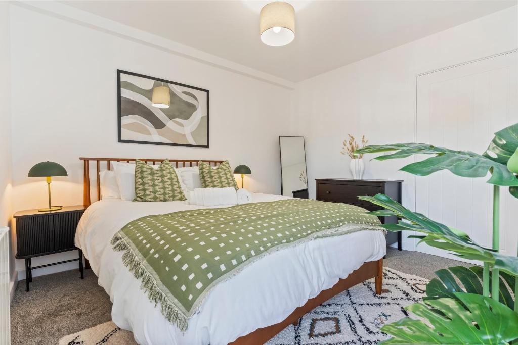 ein Schlafzimmer mit einem großen Bett und einer grünen Decke in der Unterkunft New 2 Bedroom Apartment in Burton in Burton upon Trent