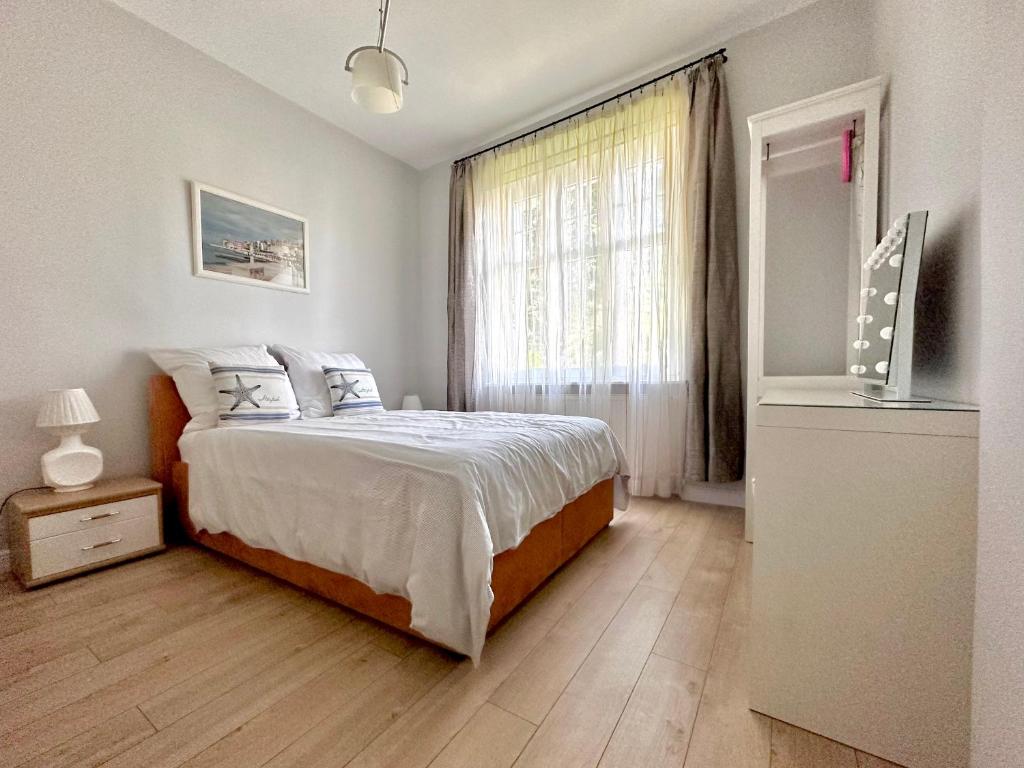 um quarto com uma cama grande e uma janela em Przy plaży Apartament BURZA em Międzyzdroje