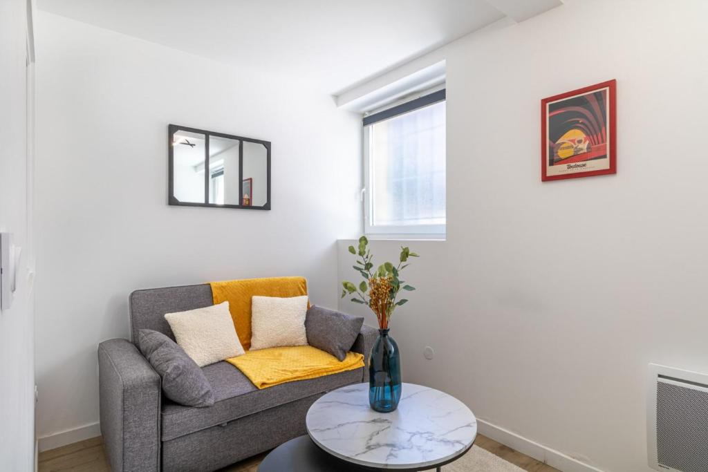 un salon avec un canapé et une table dans l'établissement Comfortable and quiet studio, à Toulouse