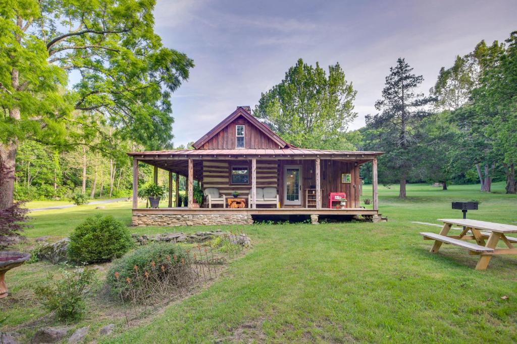 eine Blockhütte in einem Park mit einem Picknicktisch in der Unterkunft Restored Buchanan Log Cabin on 9-Mile Creek! in Reba