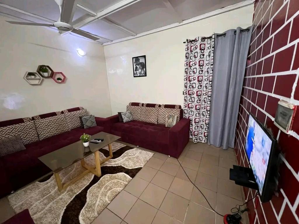 sala de estar con sofá y TV en As résidence meubles k en Uagadugú