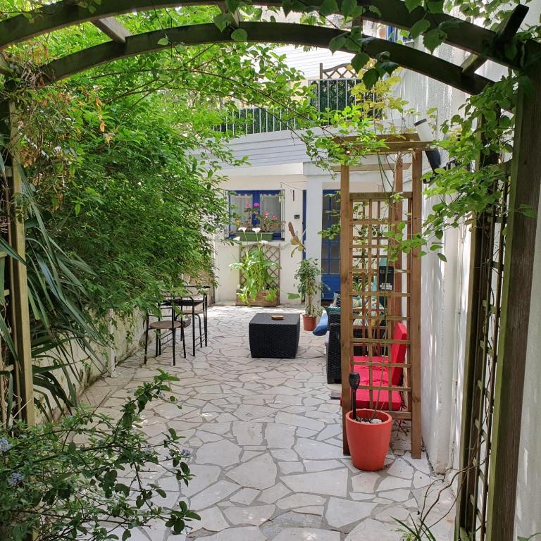 une terrasse avec une tonnelle, des tables et des chaises dans l'établissement Appartement La Garance, Gites de Daumesnil, à Morlaix
