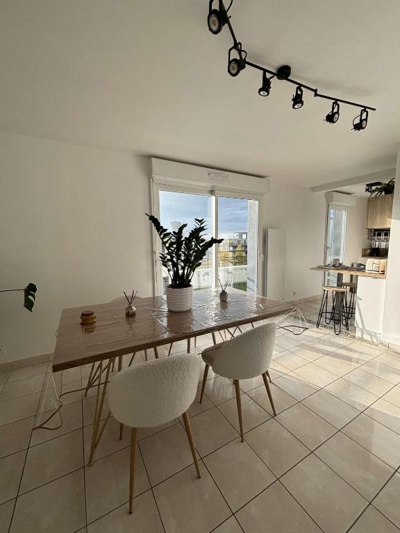 une salle à manger avec une table et des chaises en bois dans l'établissement Appartement T2, à Vannes