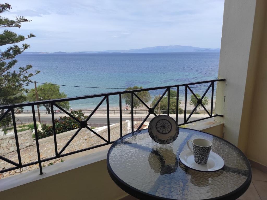 a table on a balcony with a view of the beach at GEOMELOS Georgios APARTMENTS CHIOS in Chios