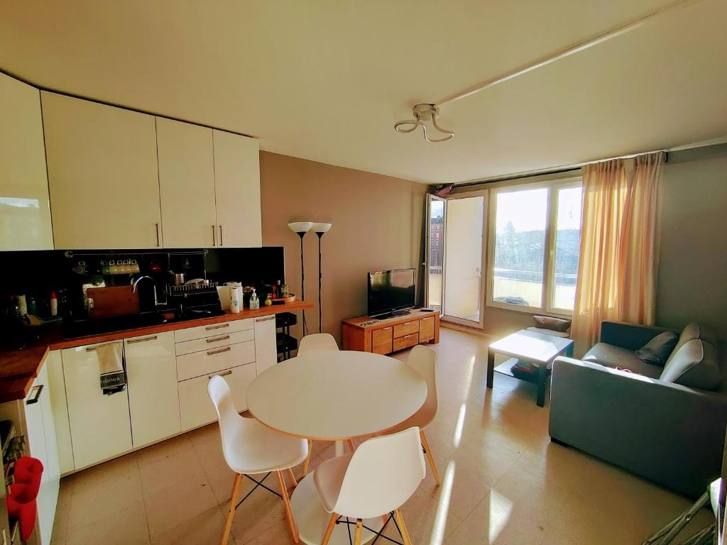 kuchnia i salon ze stołem i krzesłami w obiekcie Appartement confort Clichy JO 2024 w mieście Clichy