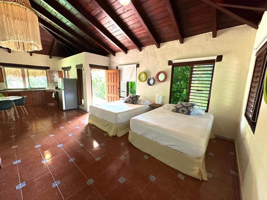 ein Schlafzimmer mit 2 Betten und eine Küche in der Unterkunft Cabaña Sofía Bacalar in Bacalar