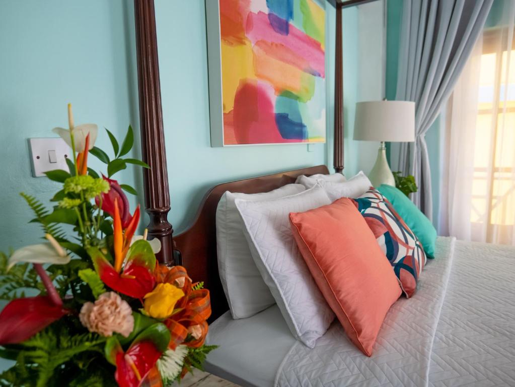ein Schlafzimmer mit einem Bett mit Blumenarrangement darauf in der Unterkunft Sutton Place Hotel in Roseau