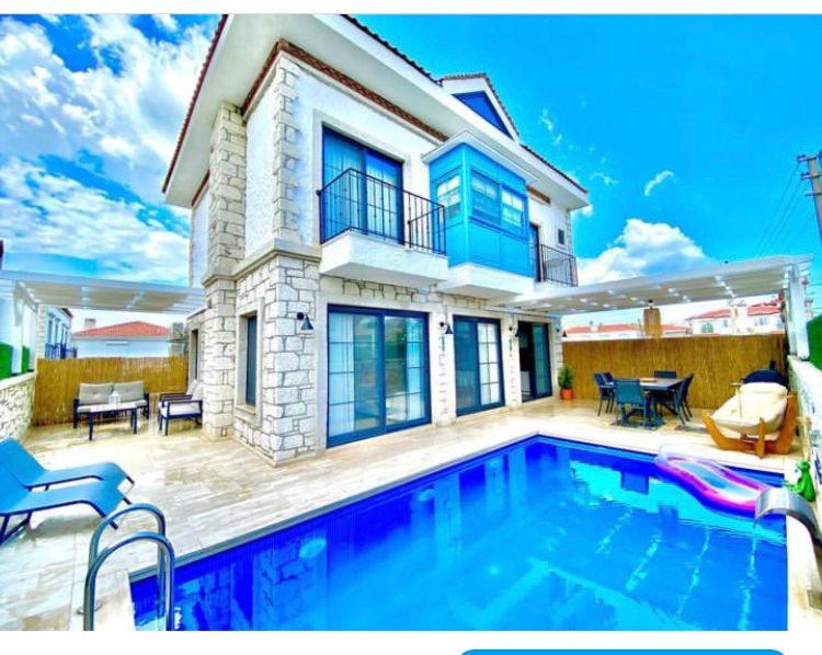 a house with a swimming pool in front of a house at Alaçatı Ayn-ı Alâ Misafir EVi in Cesme