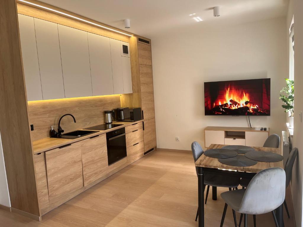 a kitchen with a table and a fire in the wall at Apartament Chodkiewicza 64 in Bydgoszcz
