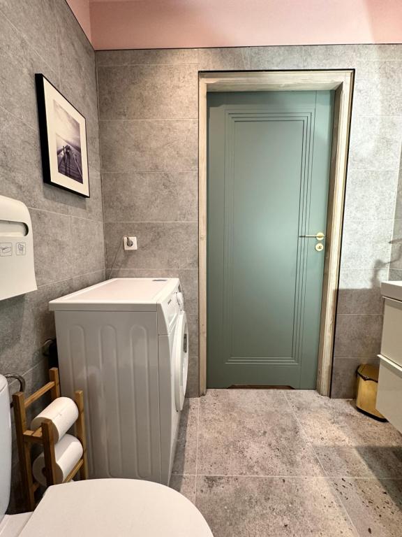 a bathroom with a toilet and a green door at Apartament Szafranowy in Wrocław