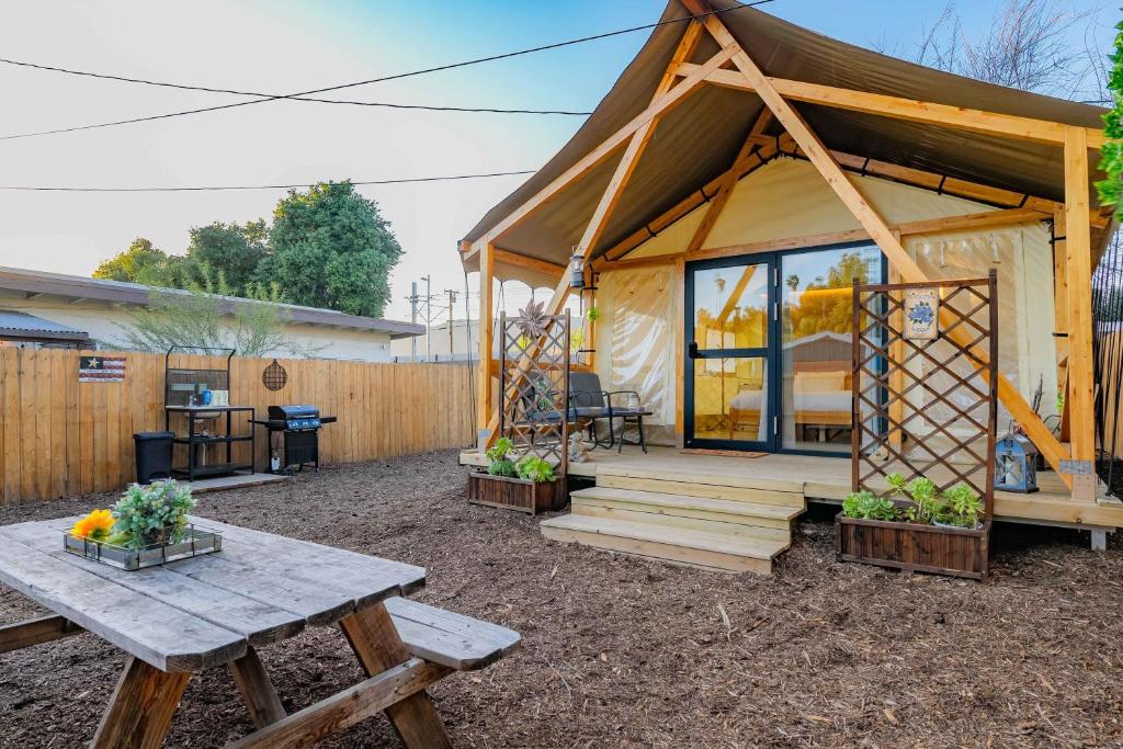 a tiny house with a picnic table and a bench at Urban Oasis Luxe Glamping with King Bed & BBQ in Glendora