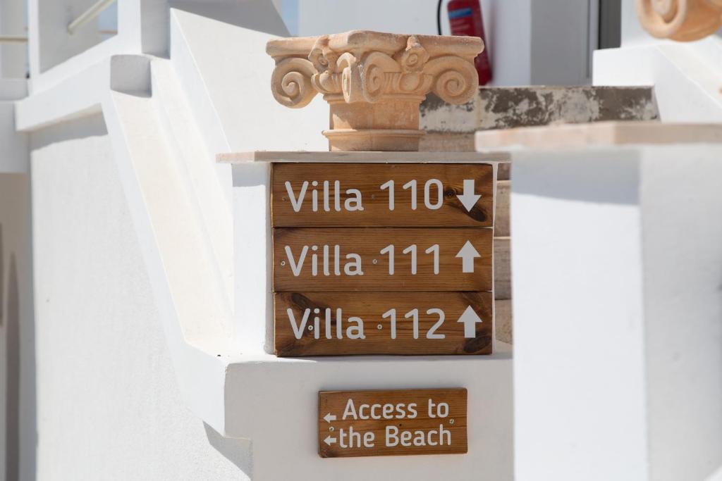 a sign for the beach on the side of a building at Poseidon Apartments and Villas by the Sea in Sounio