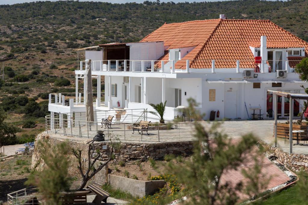 a large white house with a red roof at Poseidon Apartments and Villas by the Sea in Sounio