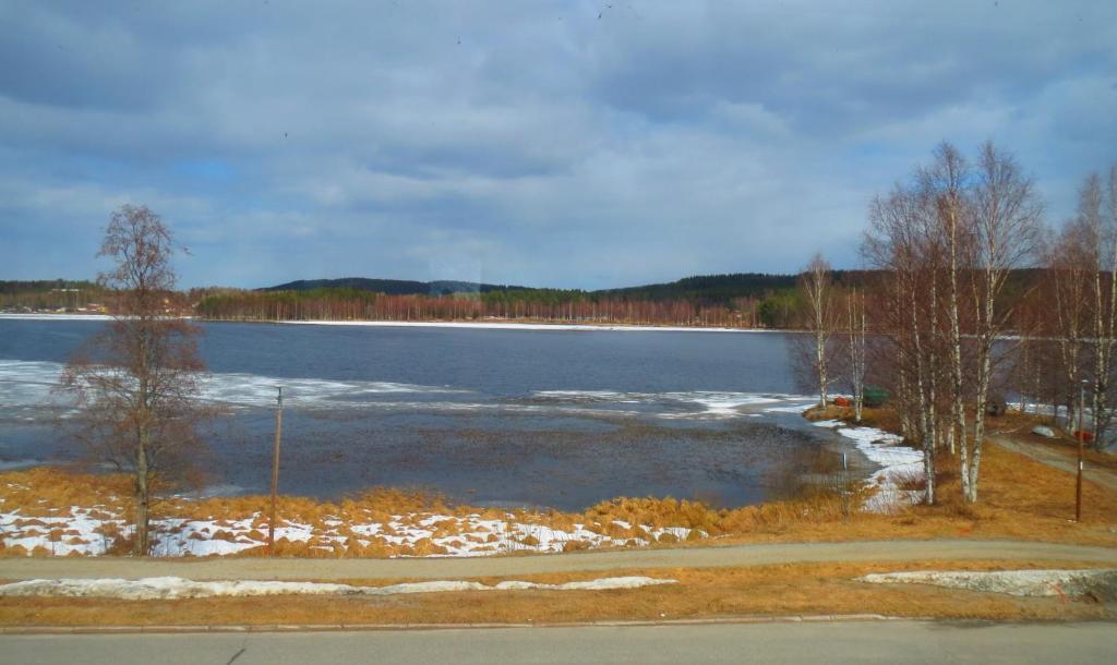 a large body of water with snow on the ground at Retrohenkinen kaksio Nurmeksen keskustassa. in Nurmes