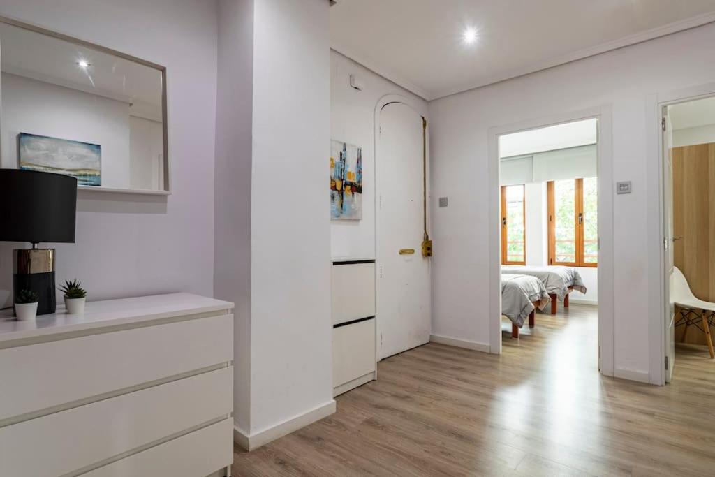 a living room with white cabinets and a bedroom at Garden Turia Downtown in Valencia