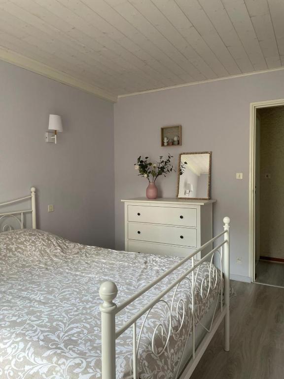 une chambre avec un lit, une commode et un miroir dans l'établissement Grande maison familiale, à Lacanau