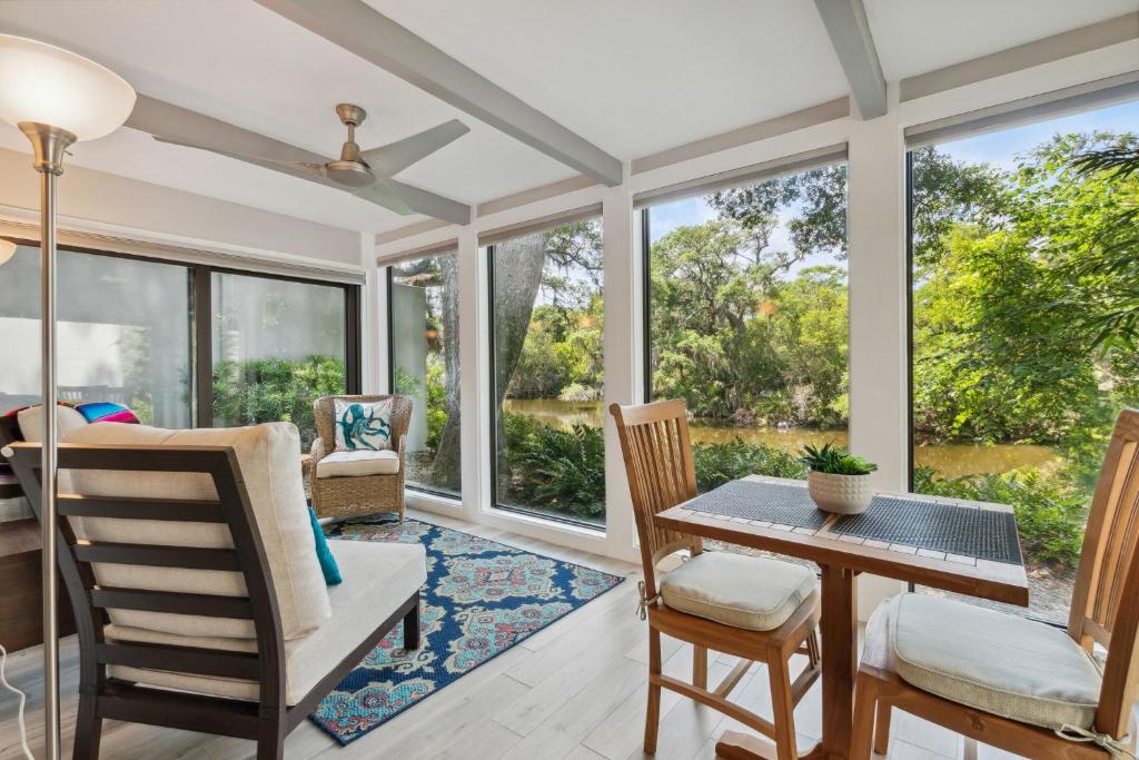 a dining room with windows and a table and chairs at 1205 Lagoon Villas in Amelia Island