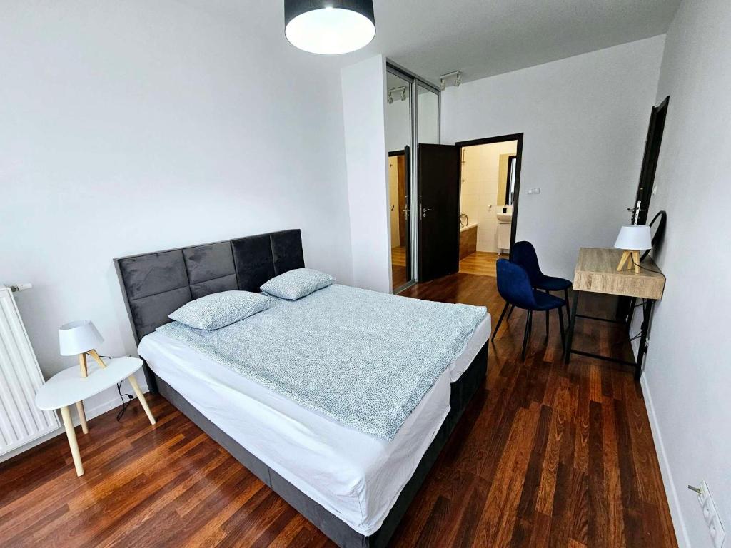 ein Schlafzimmer mit einem Bett, einem Tisch und einem Stuhl in der Unterkunft FIRST -- Green Żoliborz apartment 3 in Warschau