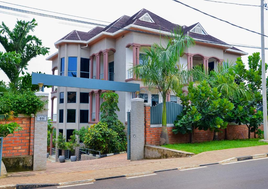 une maison avec un panneau bleu de rue devant elle dans l'établissement OMX Hotel Remera, à Kigali