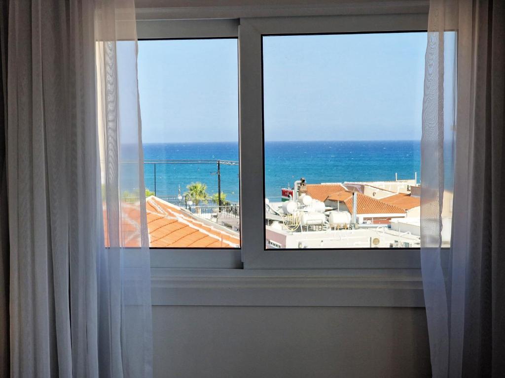 a window with a view of the ocean at Kitieos Central Apartment with Sea View in Larnaca