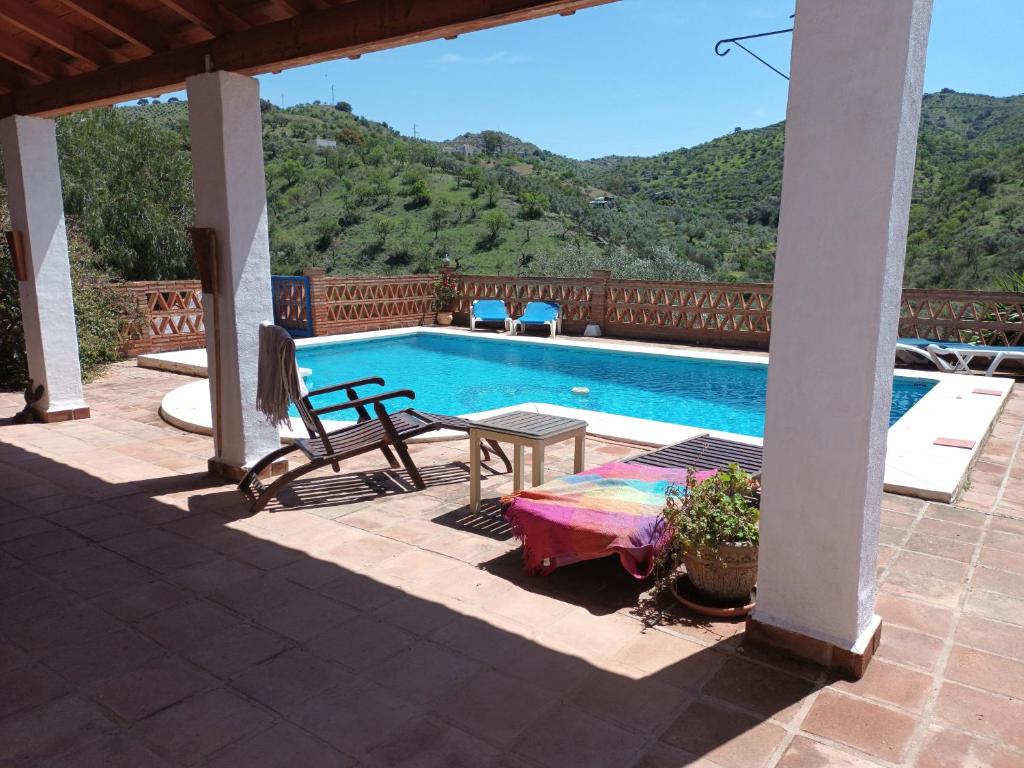 a swimming pool with a table and a bench next to it at Montana retreat in Alora