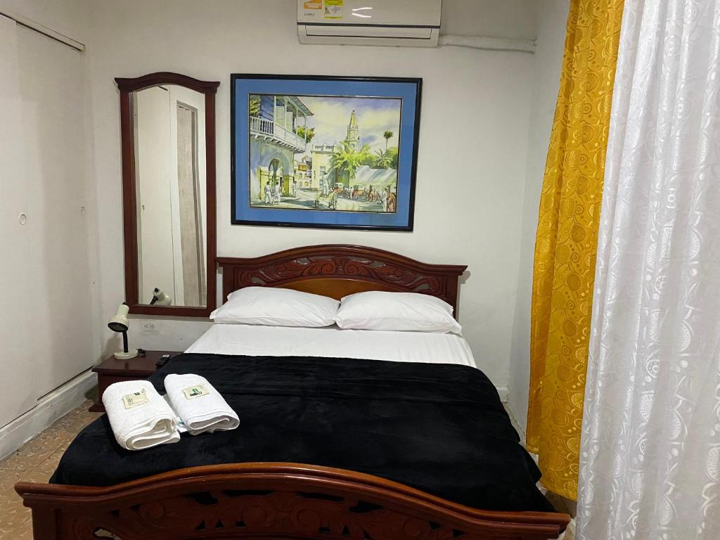 een slaapkamer met een bed met twee handdoeken erop bij Habitación Cerca de aeropuerto in Cartagena