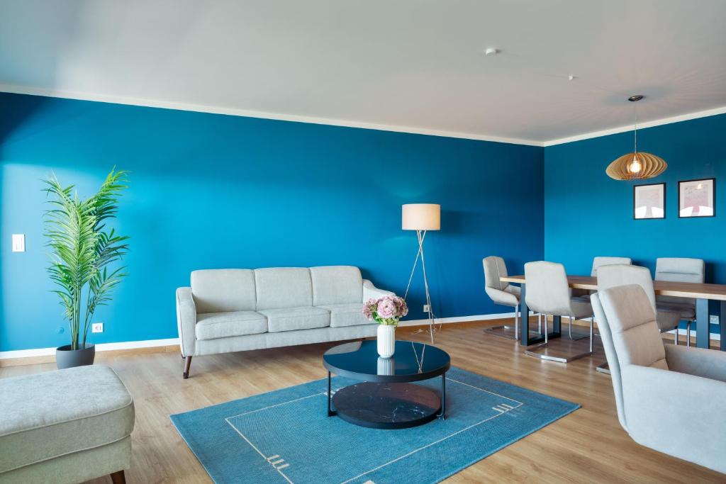een woonkamer met blauwe muren en een tafel bij Casa do Peixinho in Ericeira