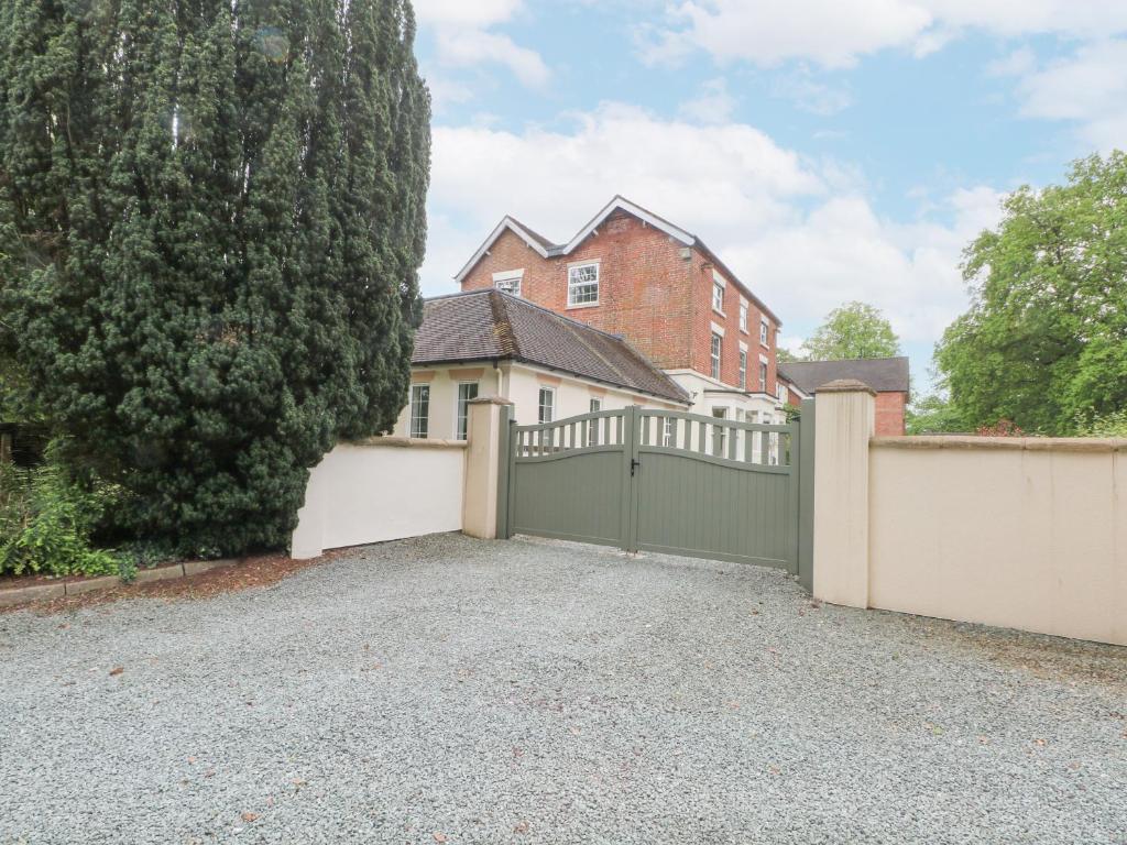 ein freistehendes Haus mit einer Garage und einem Zaun in der Unterkunft Rosehill Manor in Market Drayton