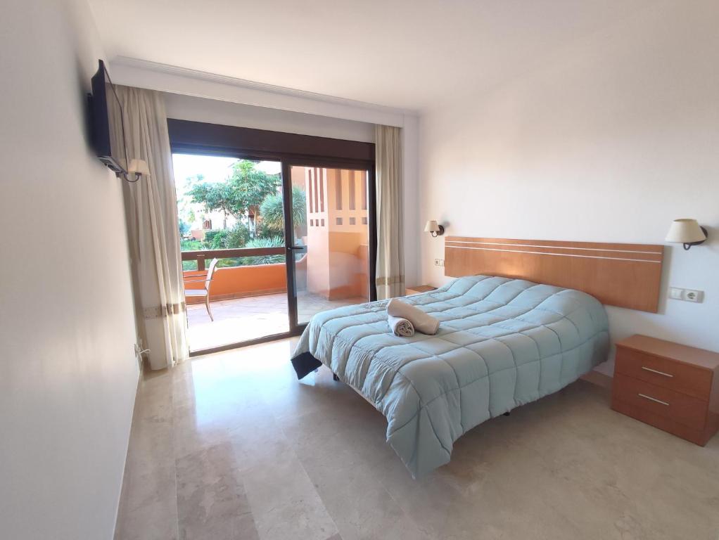 a bedroom with a bed and a sliding glass door at Paraíso Galera - Apartamento con piscina in Estepona