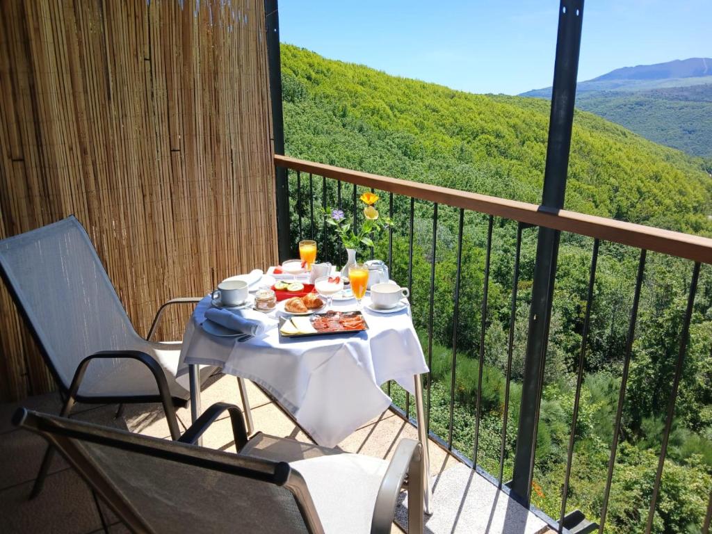 een tafel met een bord eten op een balkon bij Hotel Rural Porta Coeli - Dehesa Santa Lucía in San Martín del Castañar