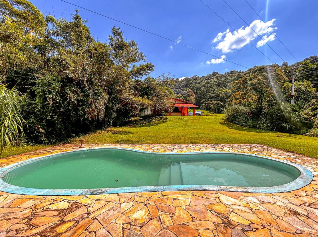 uma pequena piscina de água num quintal em Chacara com conforto e lazer em Joanopolis SP em Joanópolis