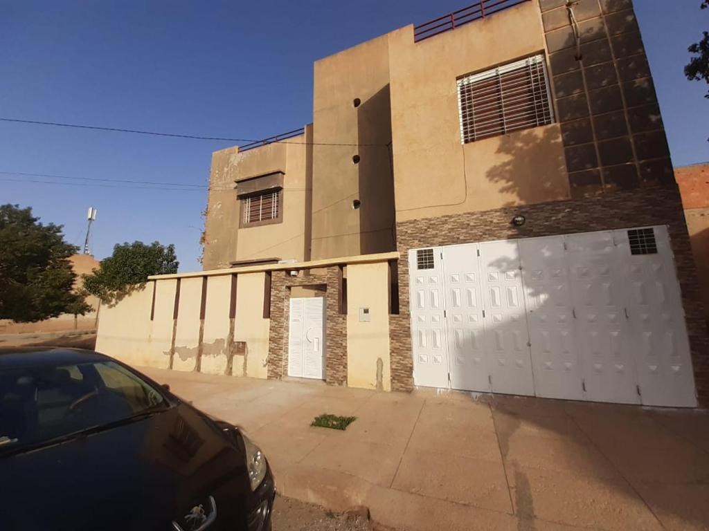 un edificio con una puerta blanca y un garaje en Villa haydi, en Oujda