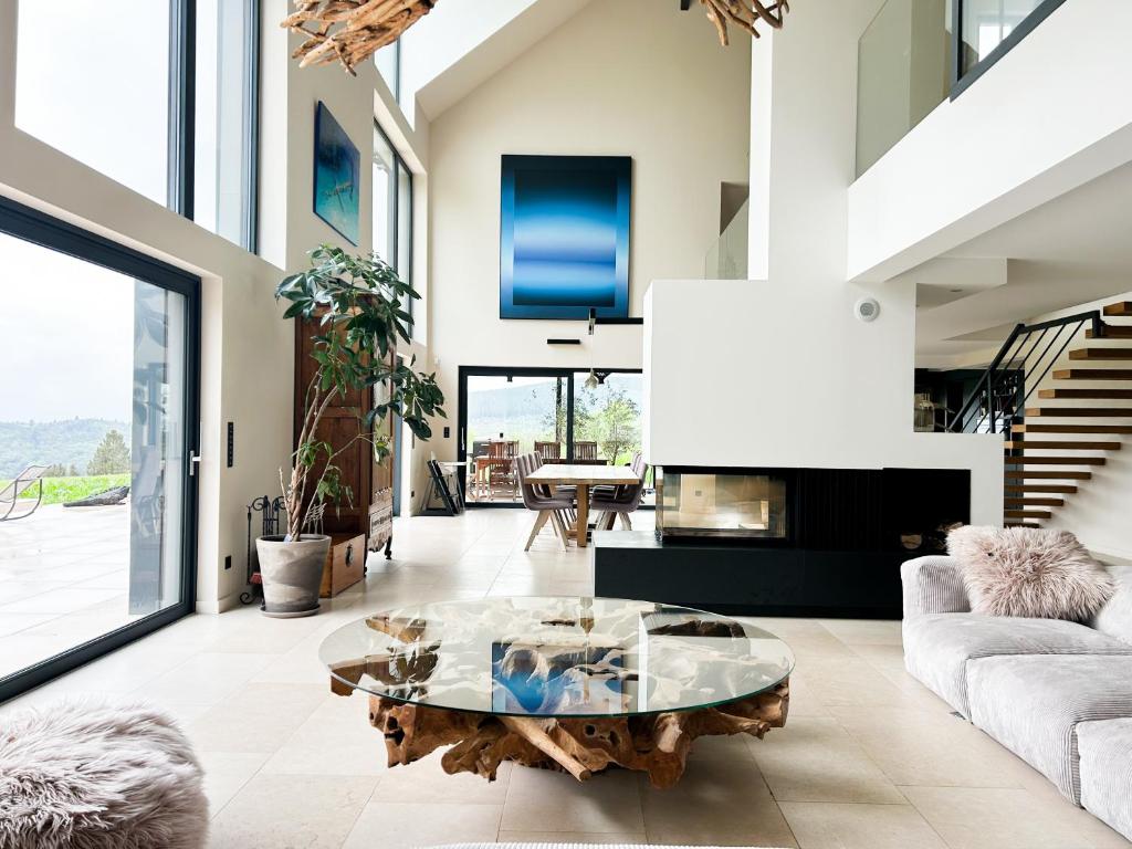 a living room with a table and a couch at La Maison Bas Lachamp - Luxuary Mountain Villa in Bellefosse