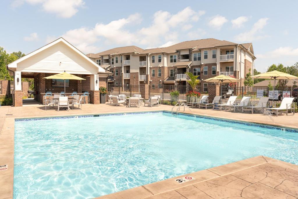 a large swimming pool with chairs and umbrellas at Modern Luxury At Overlook At Farragut Parking in Knoxville