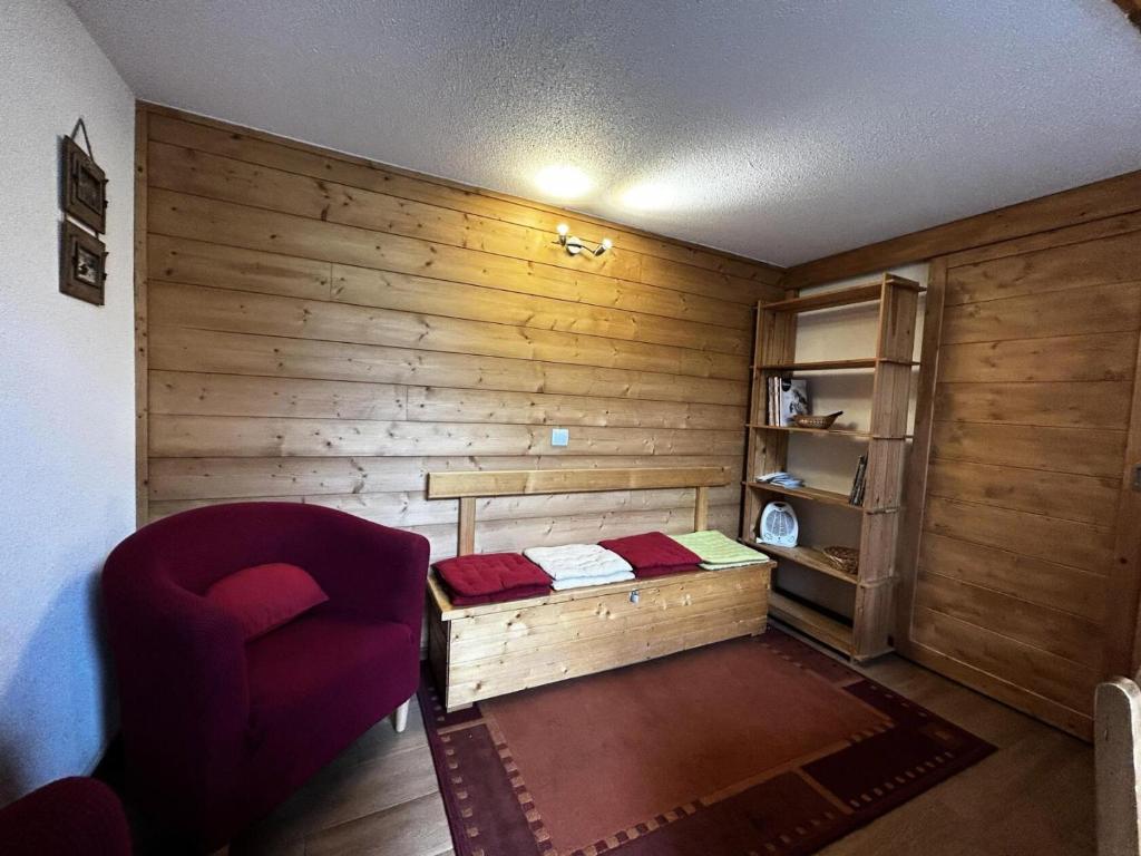 ein kleines Zimmer mit einem Bett und einem Stuhl in der Unterkunft Résidence Jetay - 3 Pièces pour 7 Personnes 464 in Les Menuires