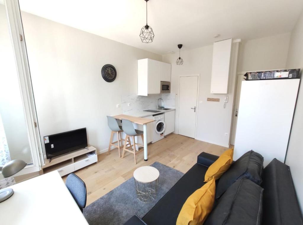 un salon avec un canapé et une petite cuisine dans l'établissement Le Petit Robert - Centre - Calme, à Toulouse