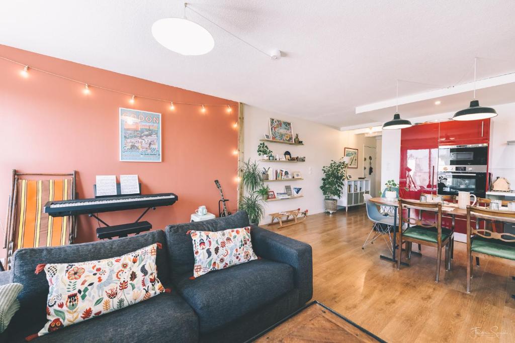 - un salon avec un canapé et un piano dans l'établissement Superbe appartement, 1min du tramway, parking, A/C, à Blagnac