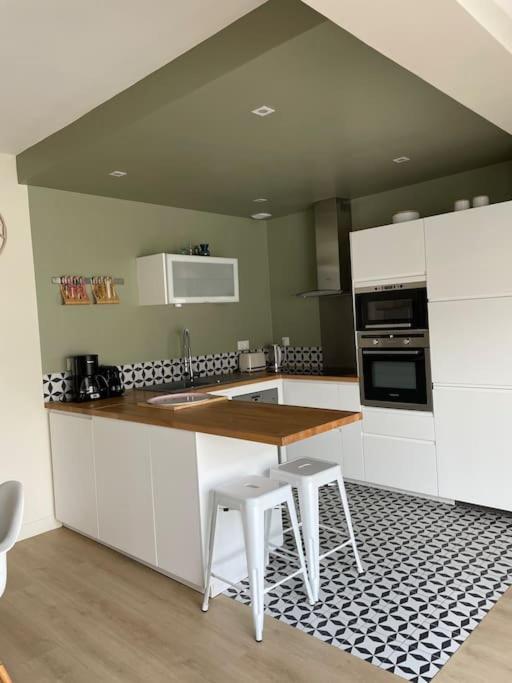 une cuisine avec des armoires blanches et un comptoir en bois dans l'établissement Villa Fleurette Arcachon l aiguillon, à Arcachon