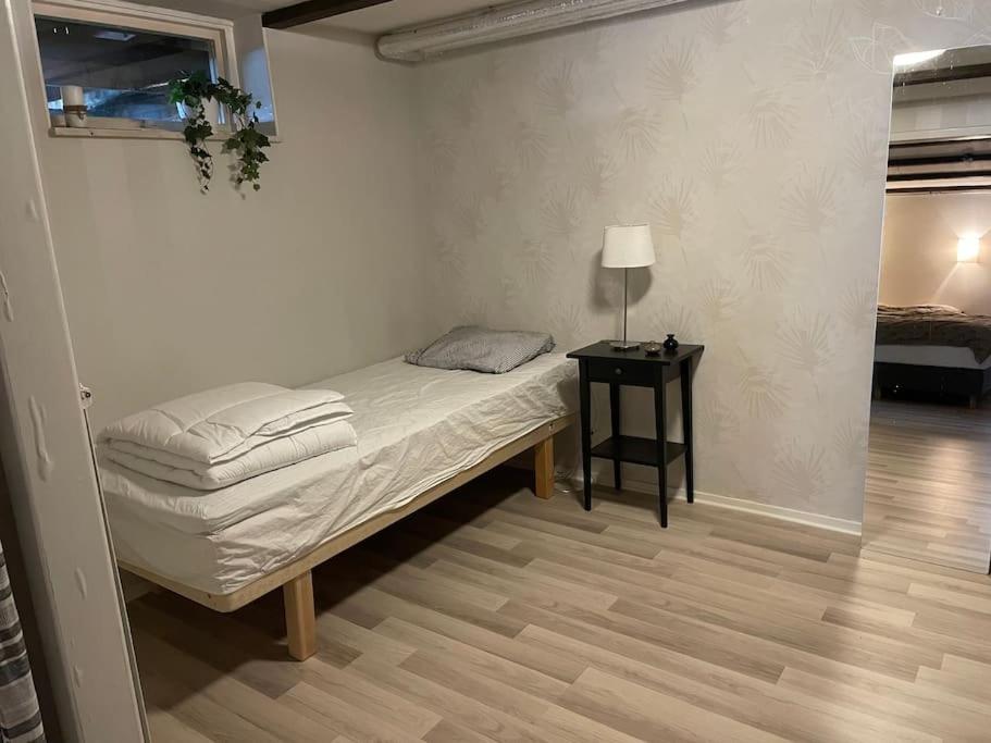 sypialnia z łóżkiem i nocną szafką z lampką w obiekcie Lägenhet Gränna w mieście Gränna