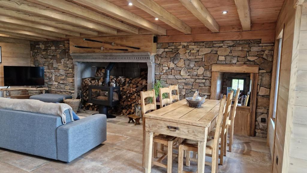 ein Wohnzimmer mit einem Holztisch und einem blauen Sofa in der Unterkunft La ferme de Jouane in Besse-et-Saint-Anastaise