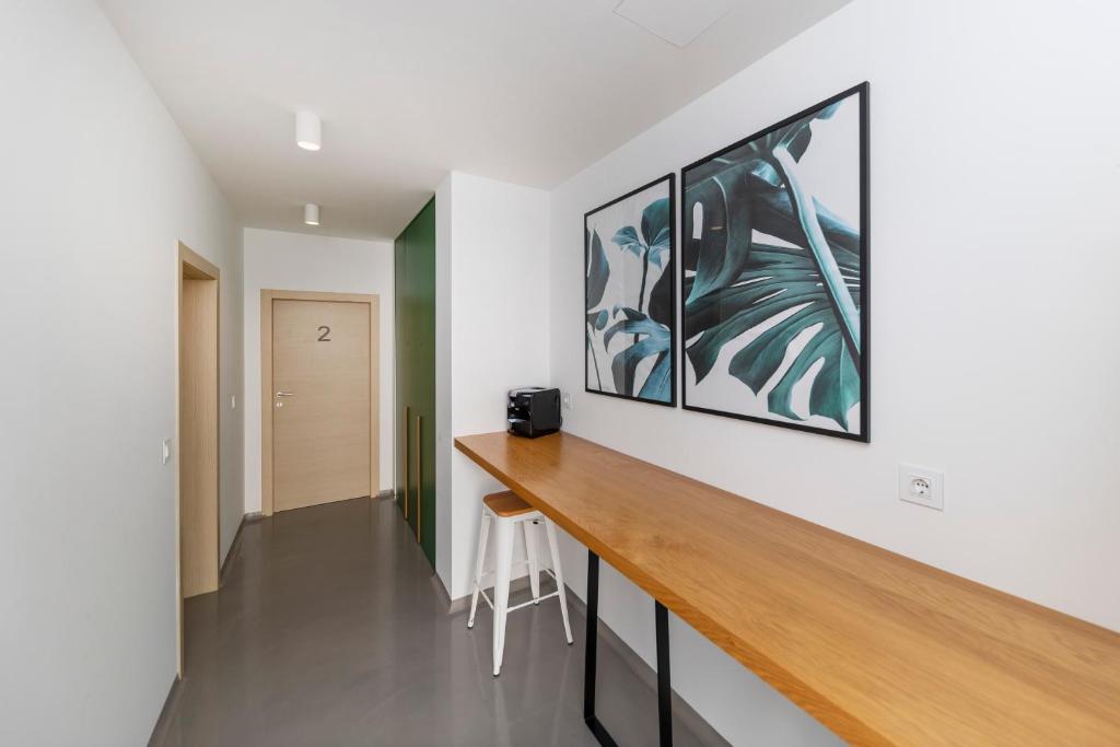 ein Home-Office mit einem Holzschreibtisch und einem Gemälde an der Wand in der Unterkunft White Rooms by Belmont Realty in Zadar
