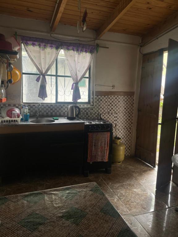 cocina con fregadero y ventana en Tres Lunas Alojamiento Doble, en Chuy