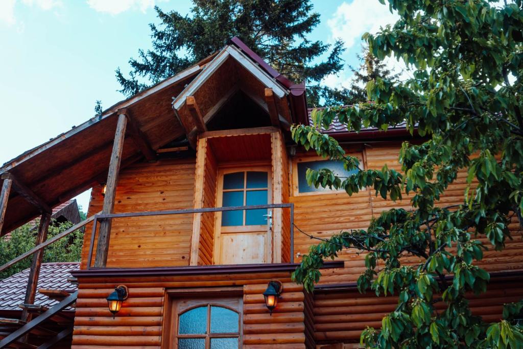 eine Blockhütte mit einem Fenster und einem Baum in der Unterkunft Fruskogorski mir in Besenovacki Prnjavor