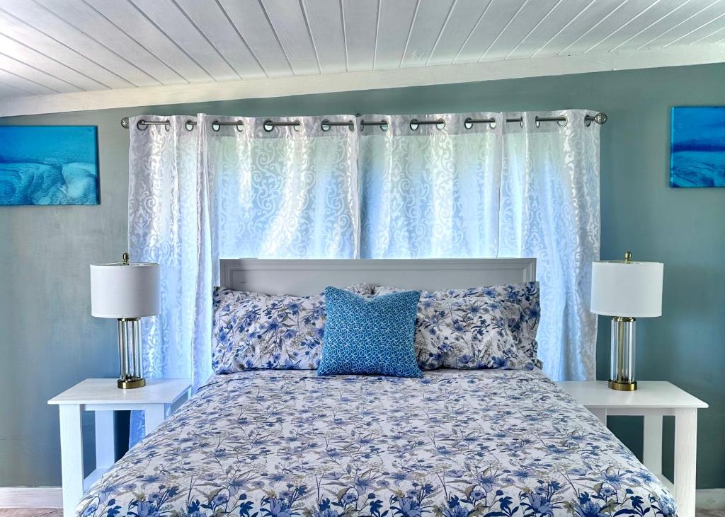 a bedroom with a bed with blue walls and white curtains at Andros Waterside Retreat in Deep Creek