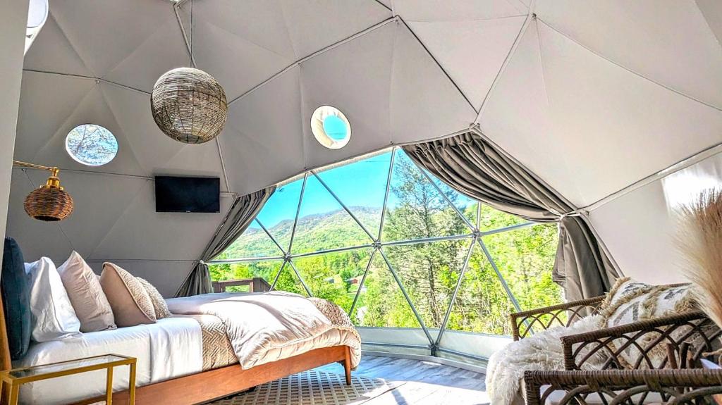 Habitación con cama y ventana grande. en Natures Dome @SmokyMountain, en Sylva