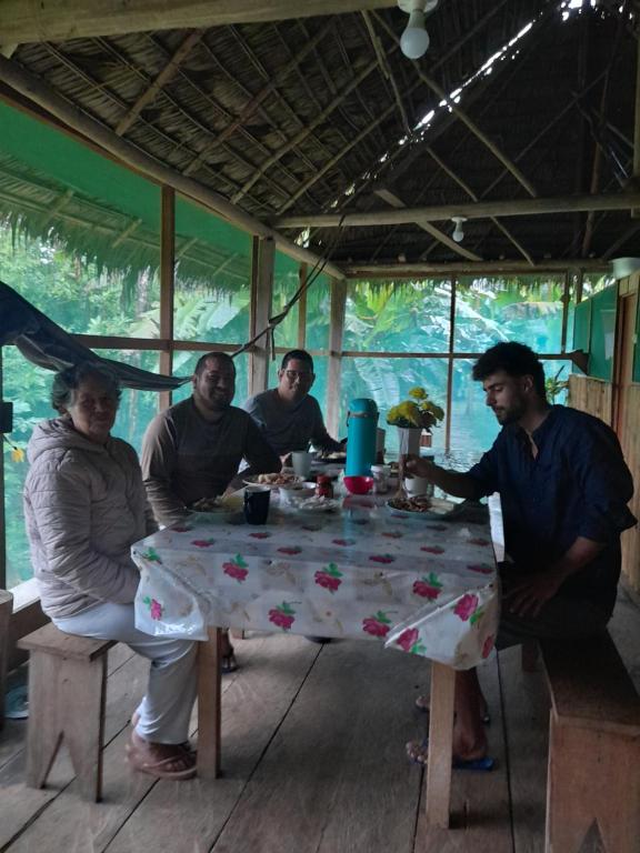 un grupo de personas sentadas alrededor de una mesa en Amazon tucuxi, en Mazán
